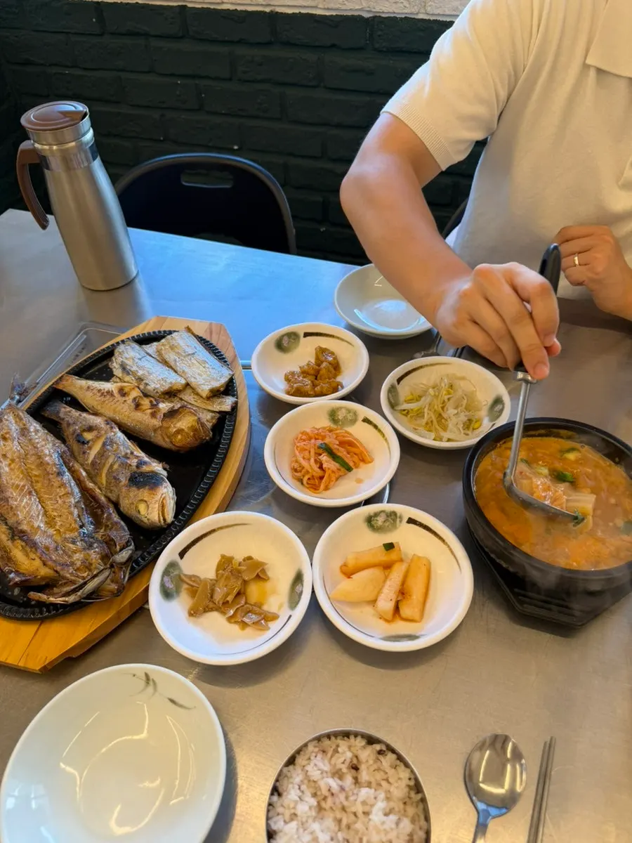 Picking flesh off a piece of grilled cutlassfish