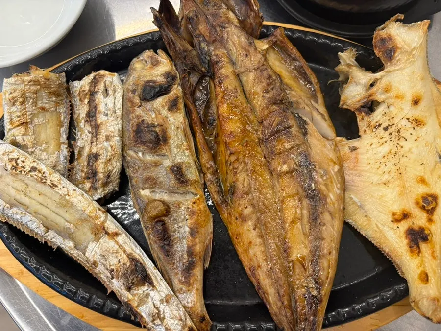 Table for two with grilled fish and kimchi jjigae