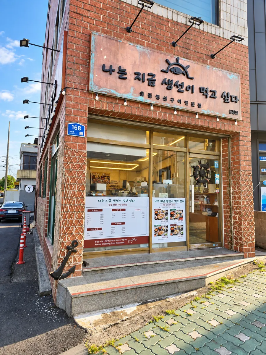 벽돌 건물에 긴 이름이 적힌 생선구이집 간판