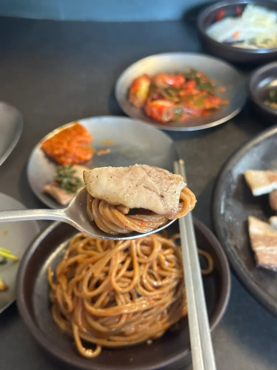 비빔메밀 위에 올린 젓삼겹 한 점