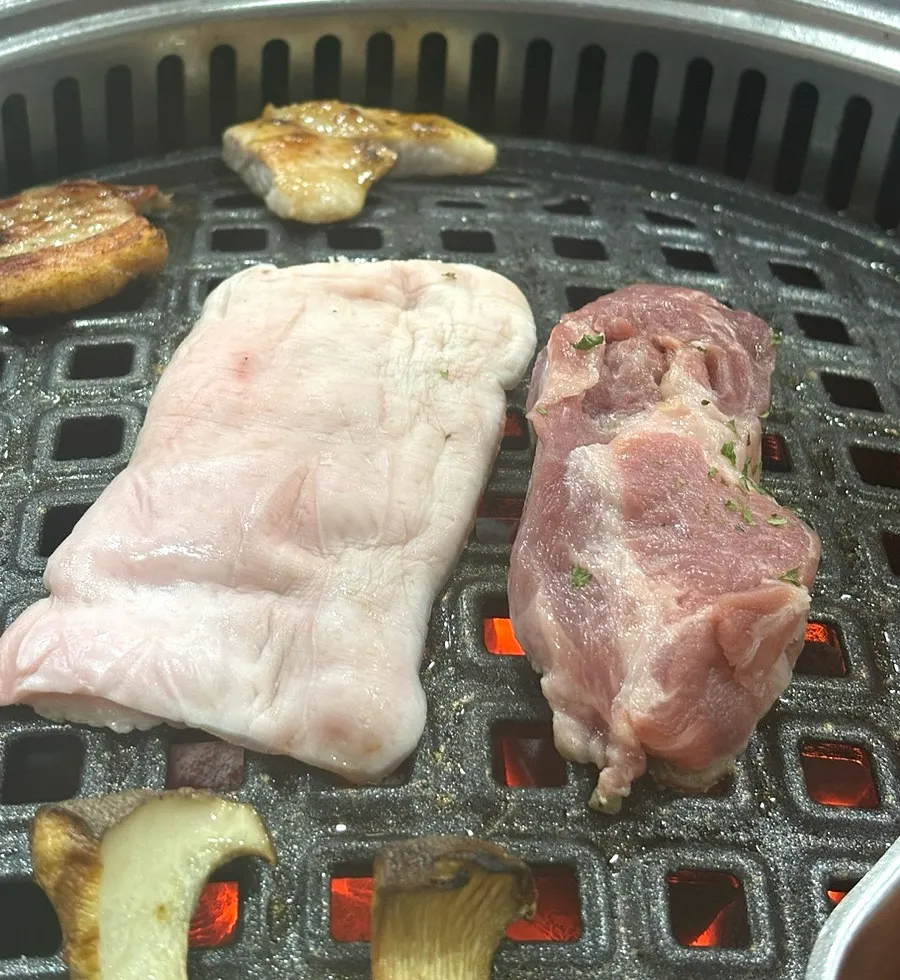 A bite of grilled seaweed topped with meat, pollack roe mayo, and pickled peppers