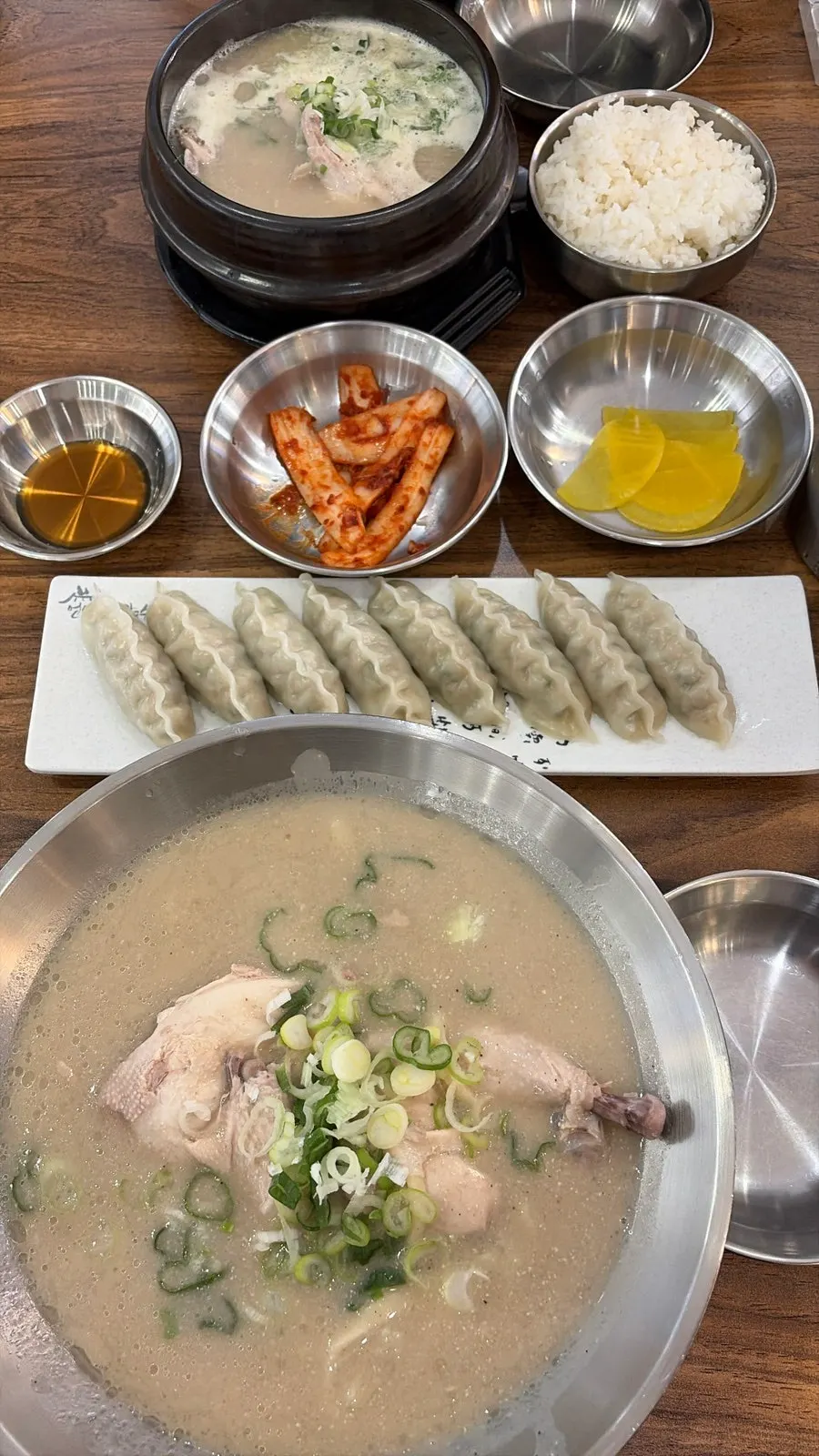 A bowl of dak kalguksu with half a chicken inside