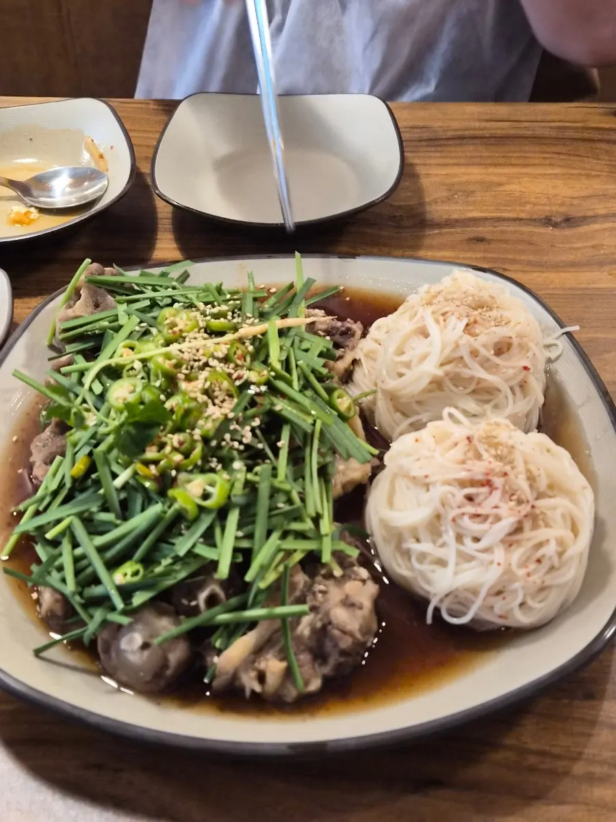 ニラと素麺がのった牛テール蒸しの皿