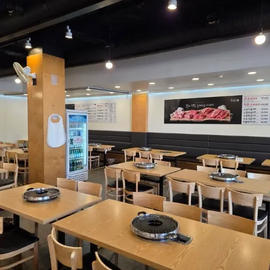 테이블이 넉넉하게 놓인 고깃집 홀 전경