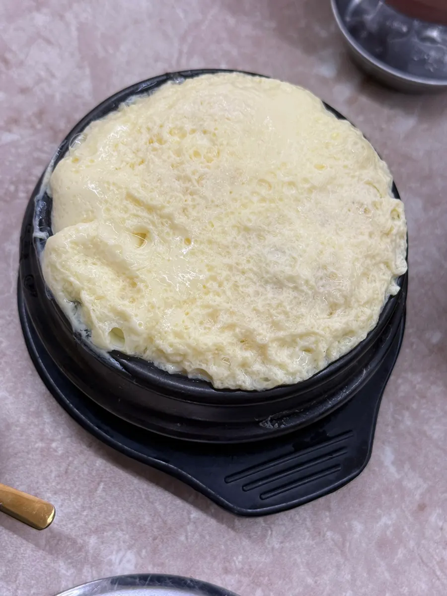 Steamed egg custard filling an earthenware bowl