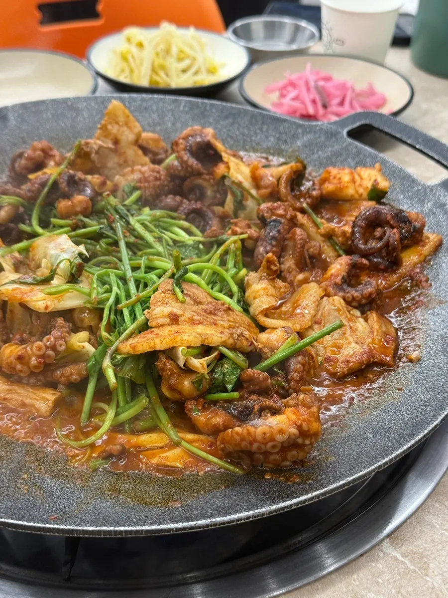 Griddle with black pork belly arranged around the edge