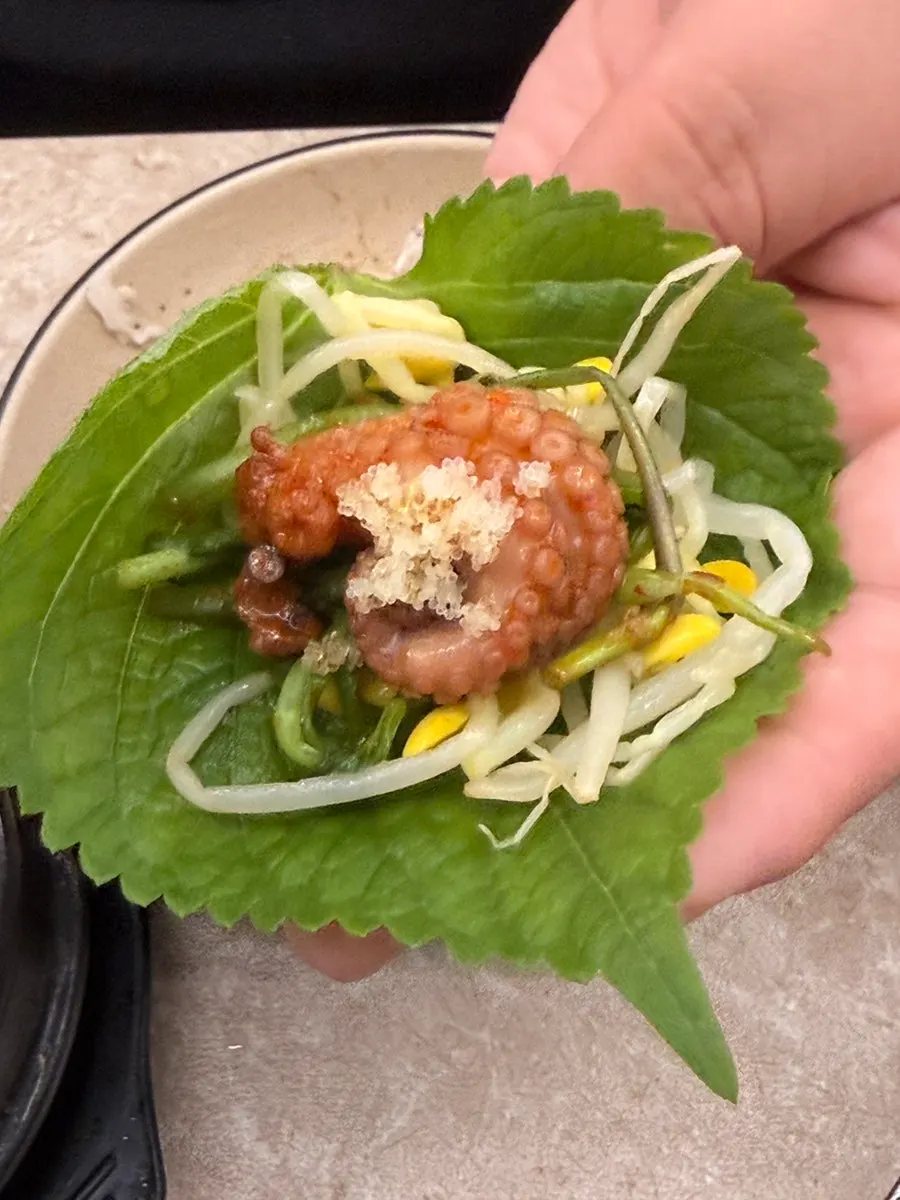A gim wrap with pork belly, jjukkumi, and flying fish roe
