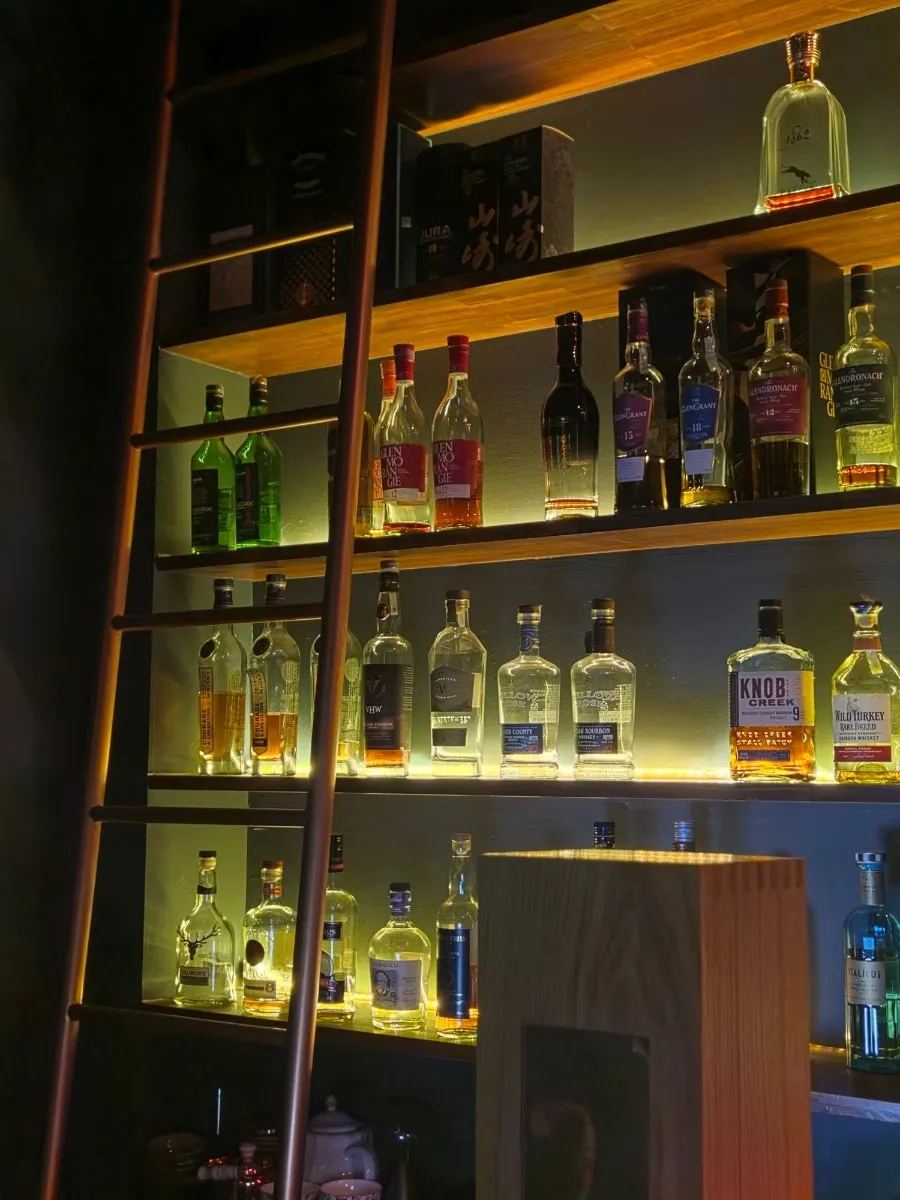 Bar shelves packed with whiskey and liqueurs