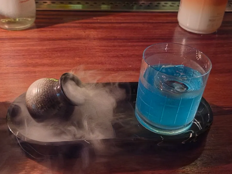 Dry ice smoke rising from the Grand Bleu cocktail