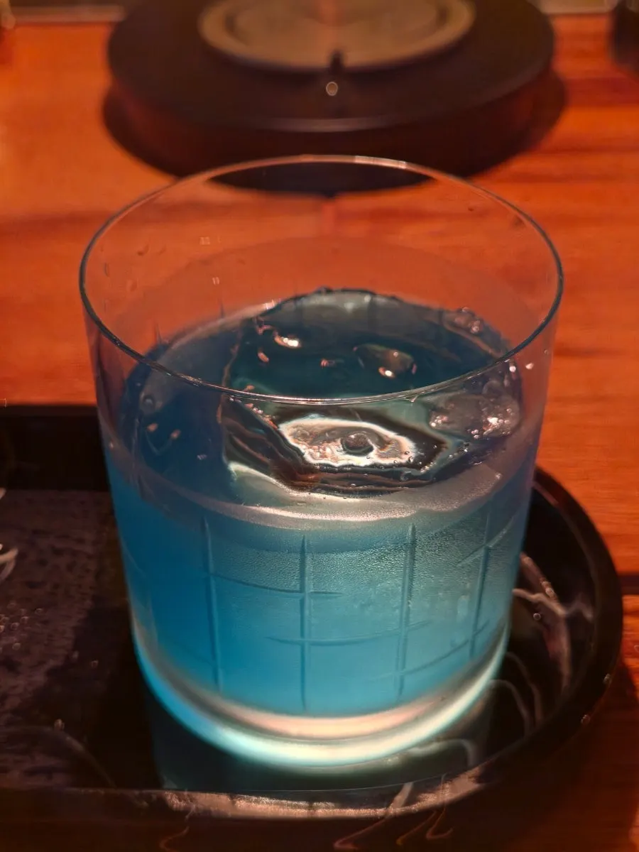 Blue cocktail glass with crystal-clear ice