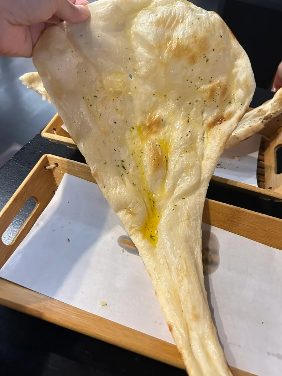 Torn naan pieces alongside curry