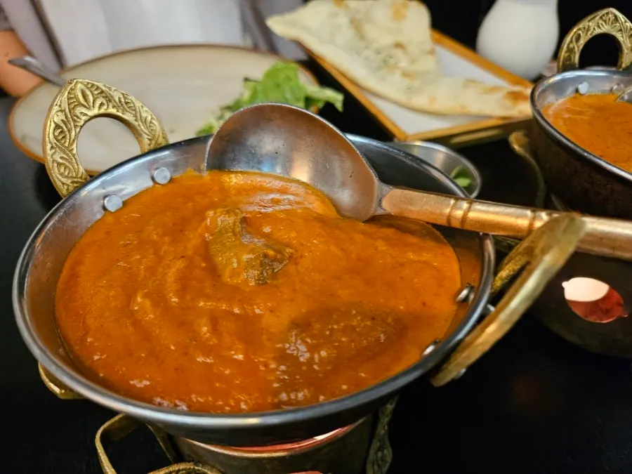 Table spread with garlic naan, butter naan, and curry