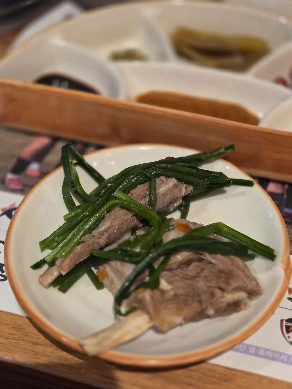 A piece of boiled lamb with chives and dipping sauce