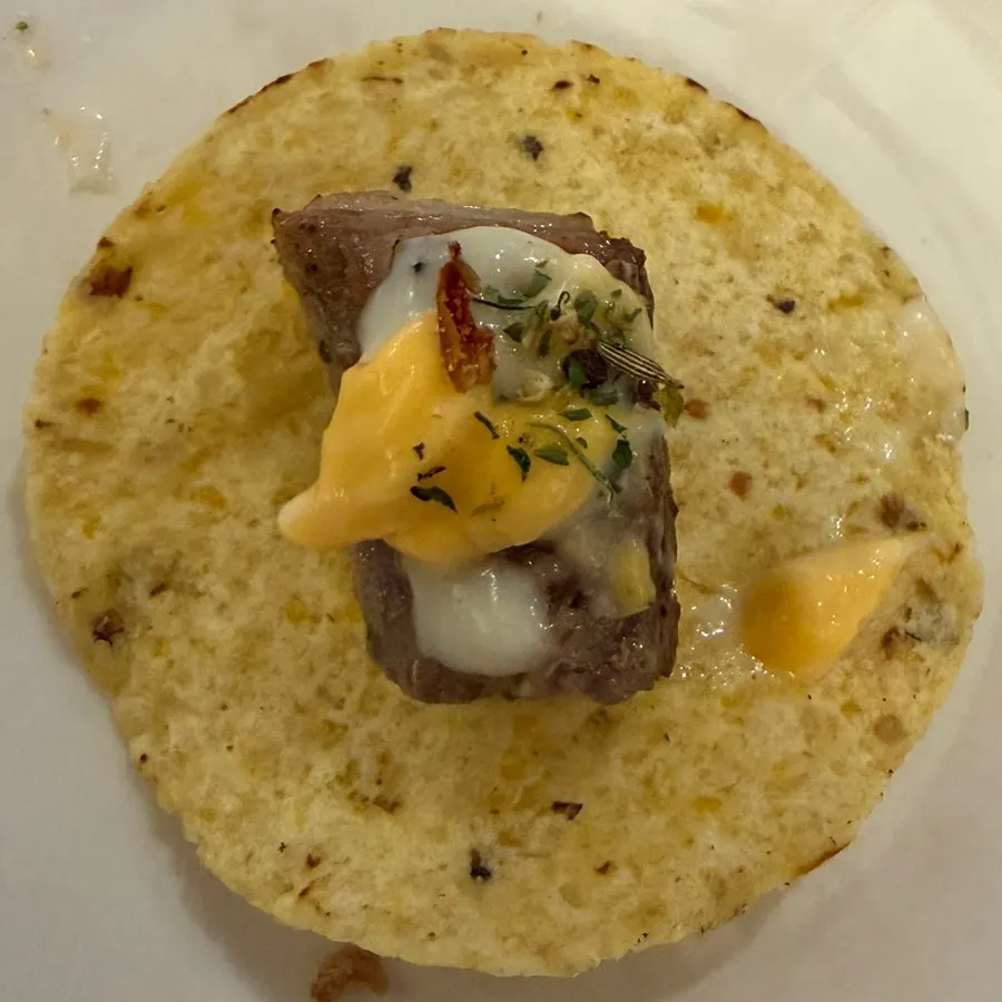 Nachos topped with meat, cheese, and herbs