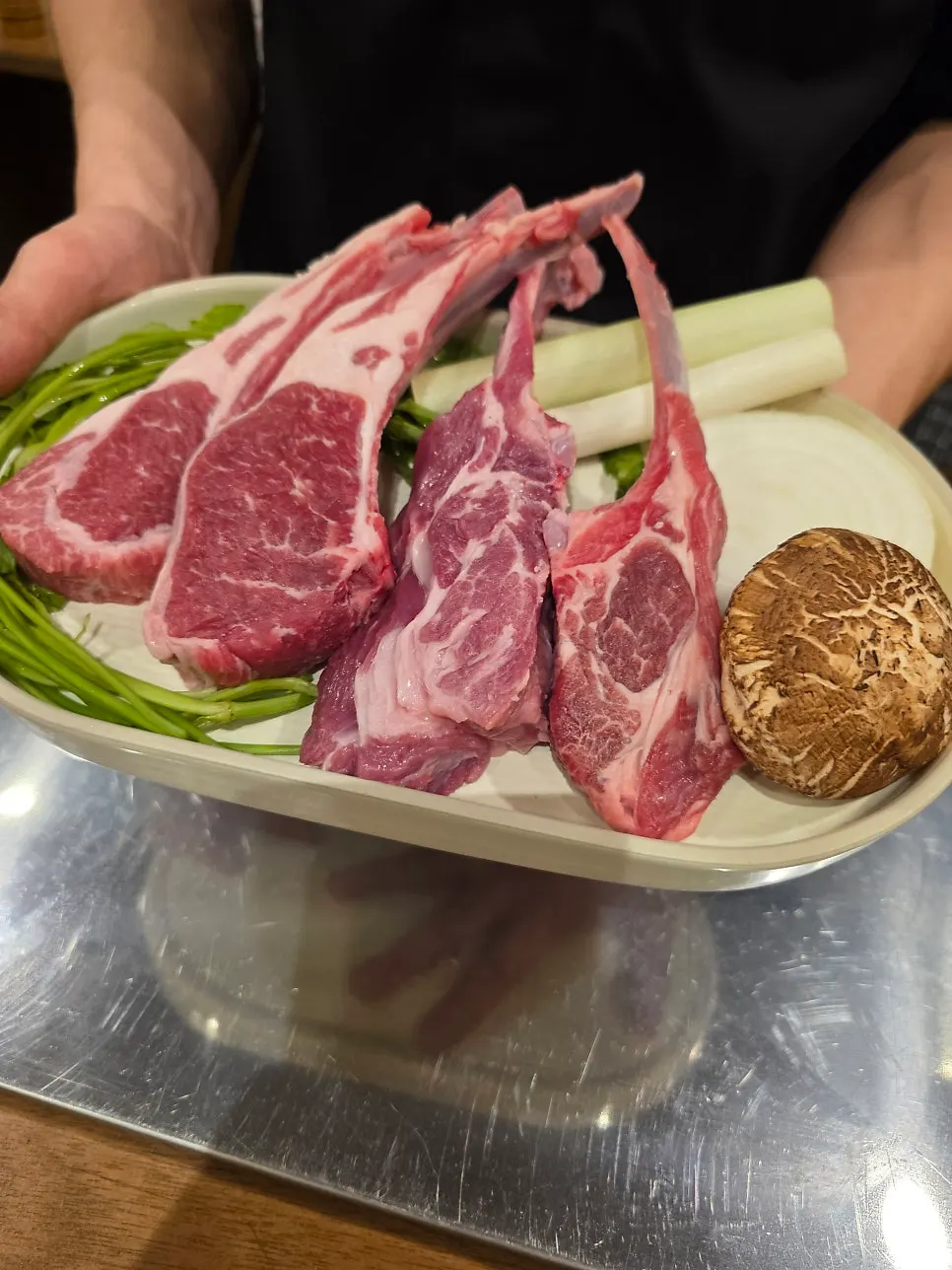 Raw shoulder rack and French rack set out before grilling