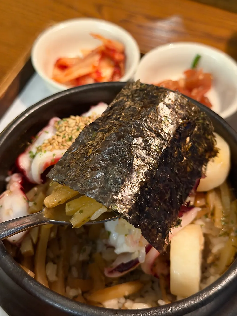 A spoonful of sotbap topped with octopus