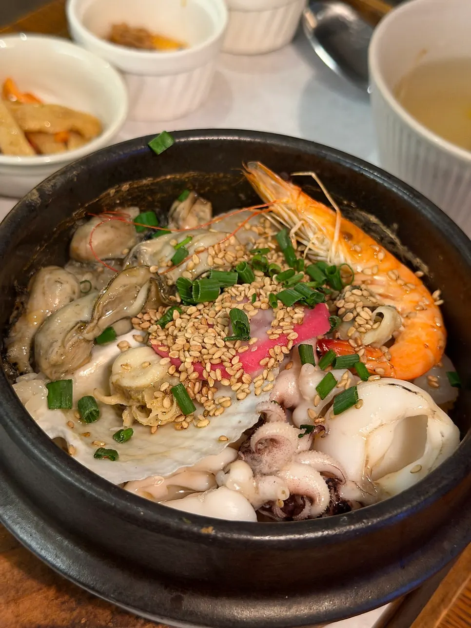 Seafood sotbap piled with whole shrimp, oysters, and squid