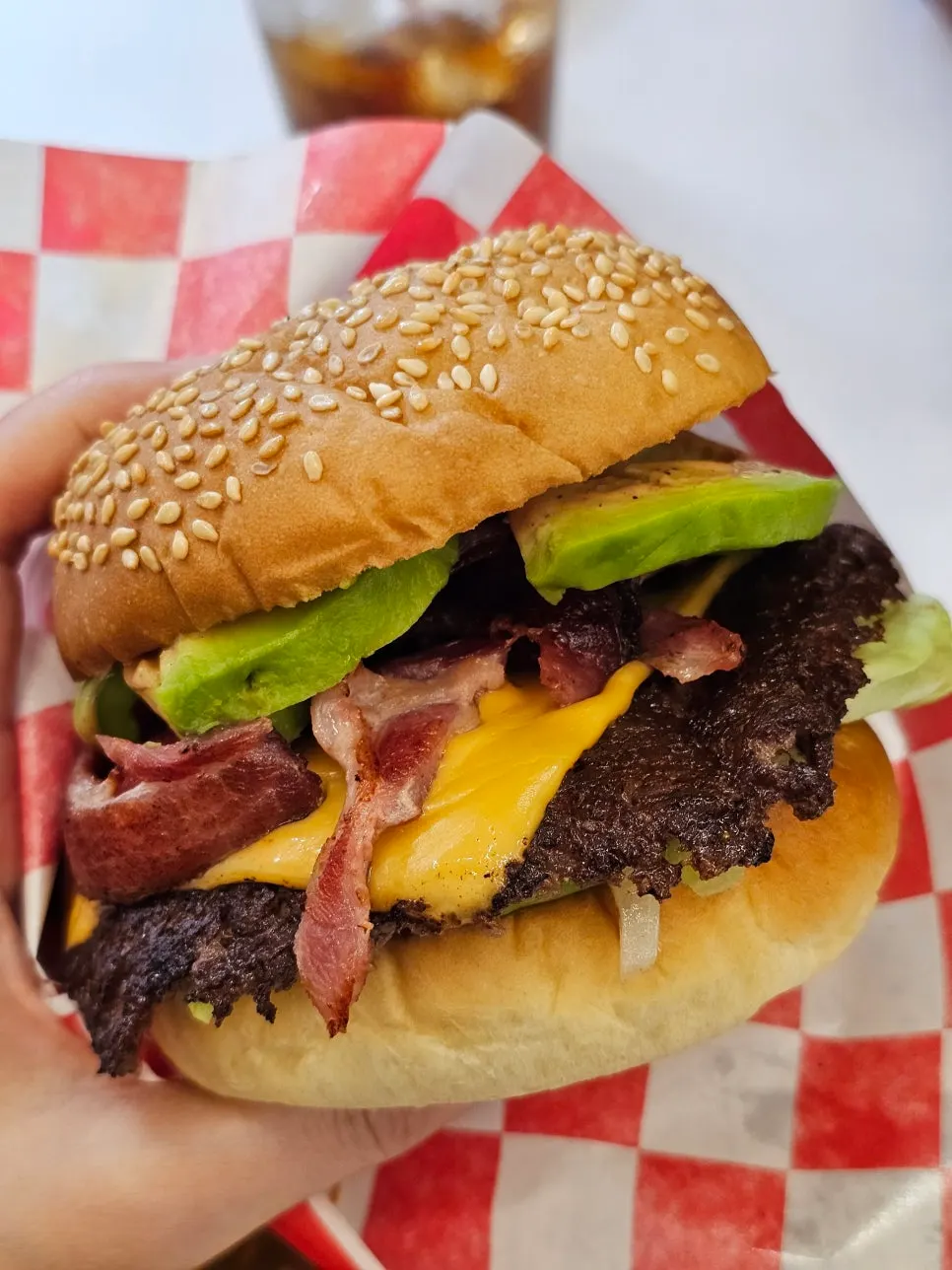 Cross-section of the burger showing avocado, bacon, and beef patty