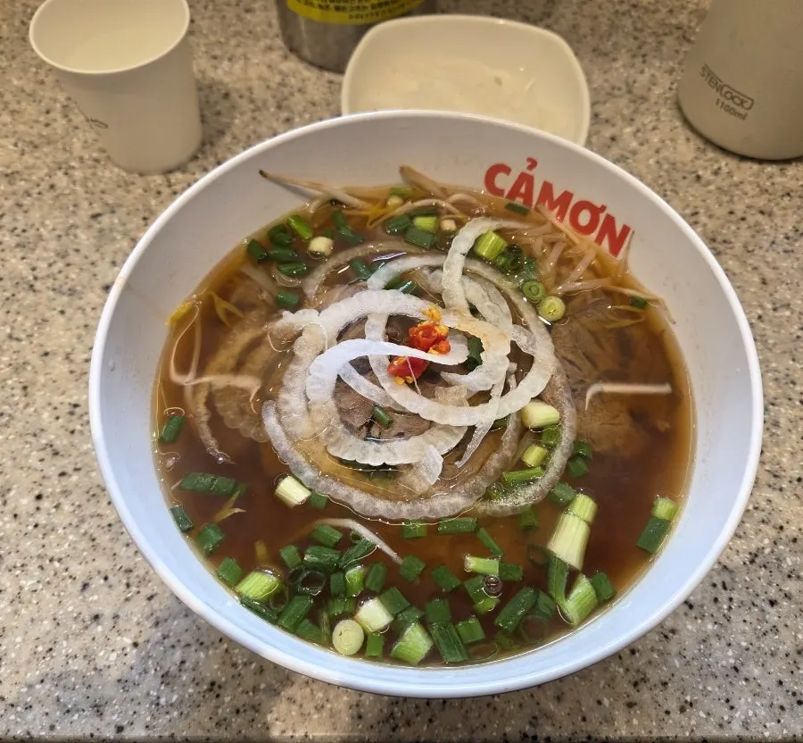 A bowl of Kkamon's boiled pork pho topped with pork