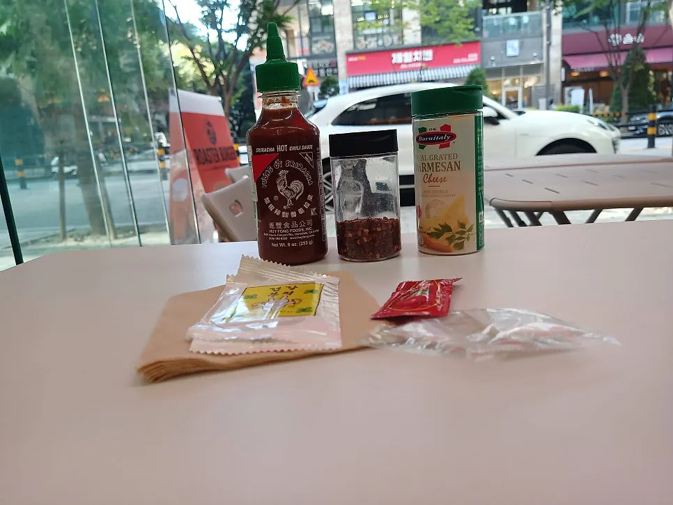 Self-serve bar with parmesan cheese and sriracha