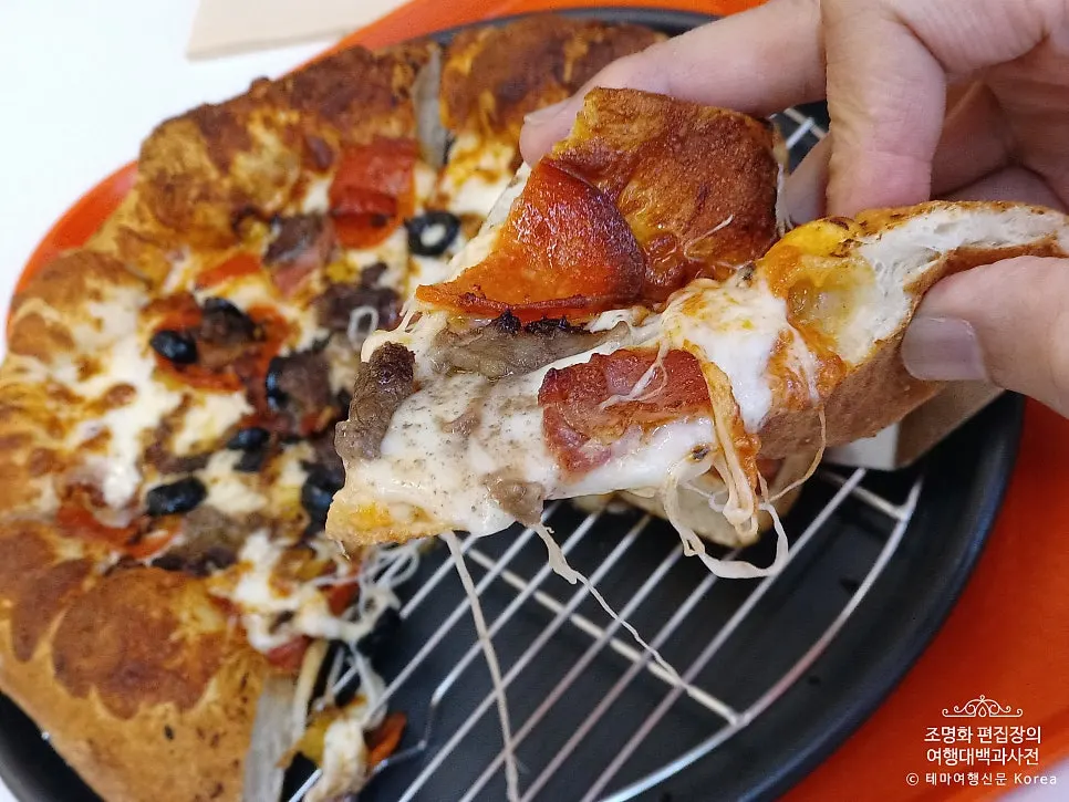 A warm pizza slice picked up by hand