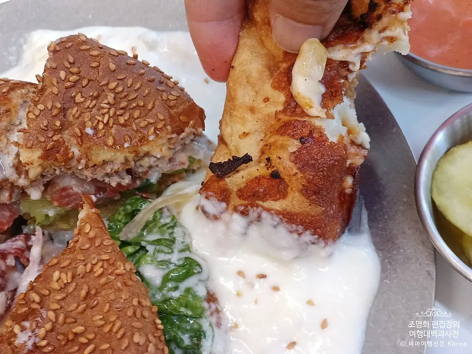 Dipping a pizza crust into white sauce