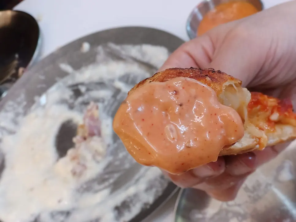 Table alternating bites of white burger and pizza