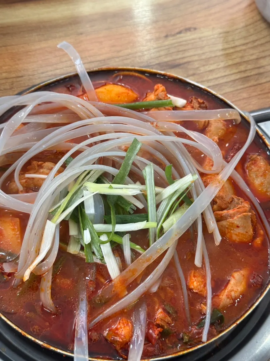 Pot of dakbokkeumtang with added glass noodles