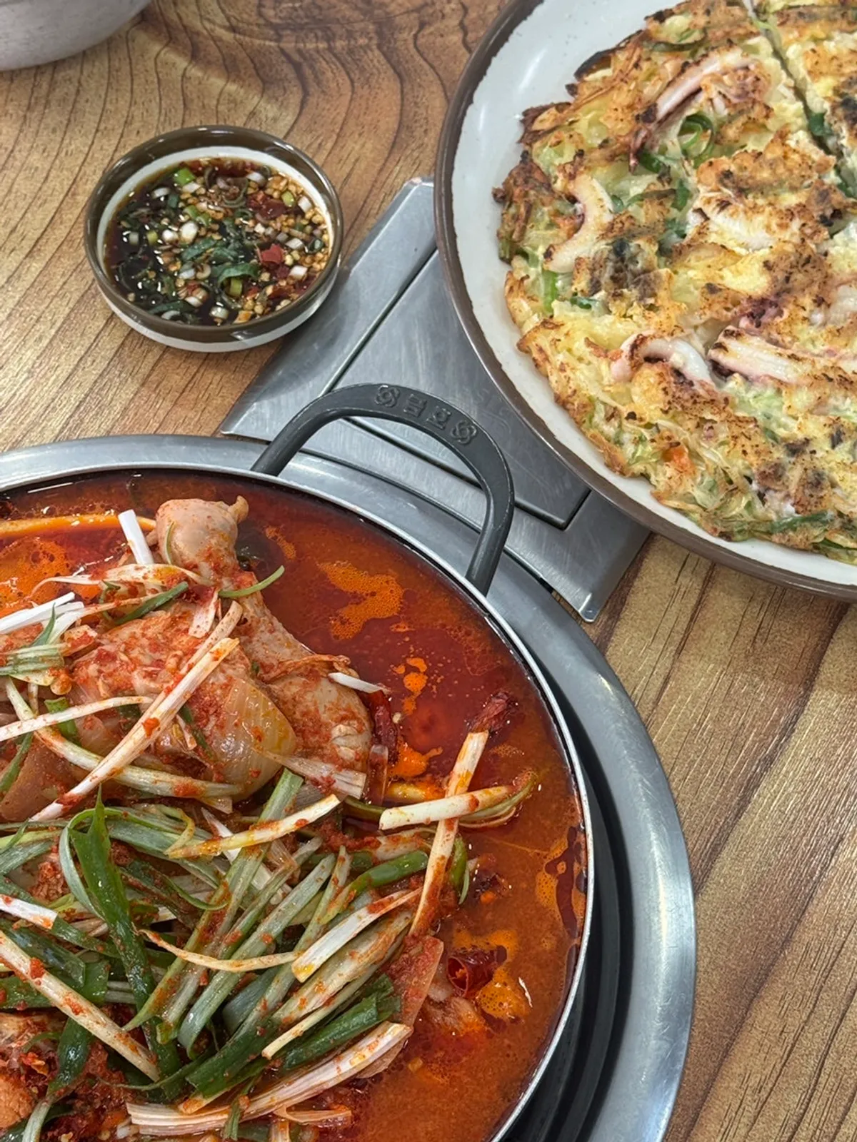 Full spread of dakbokkeumtang, cockle bibimbap, and seafood pancake
