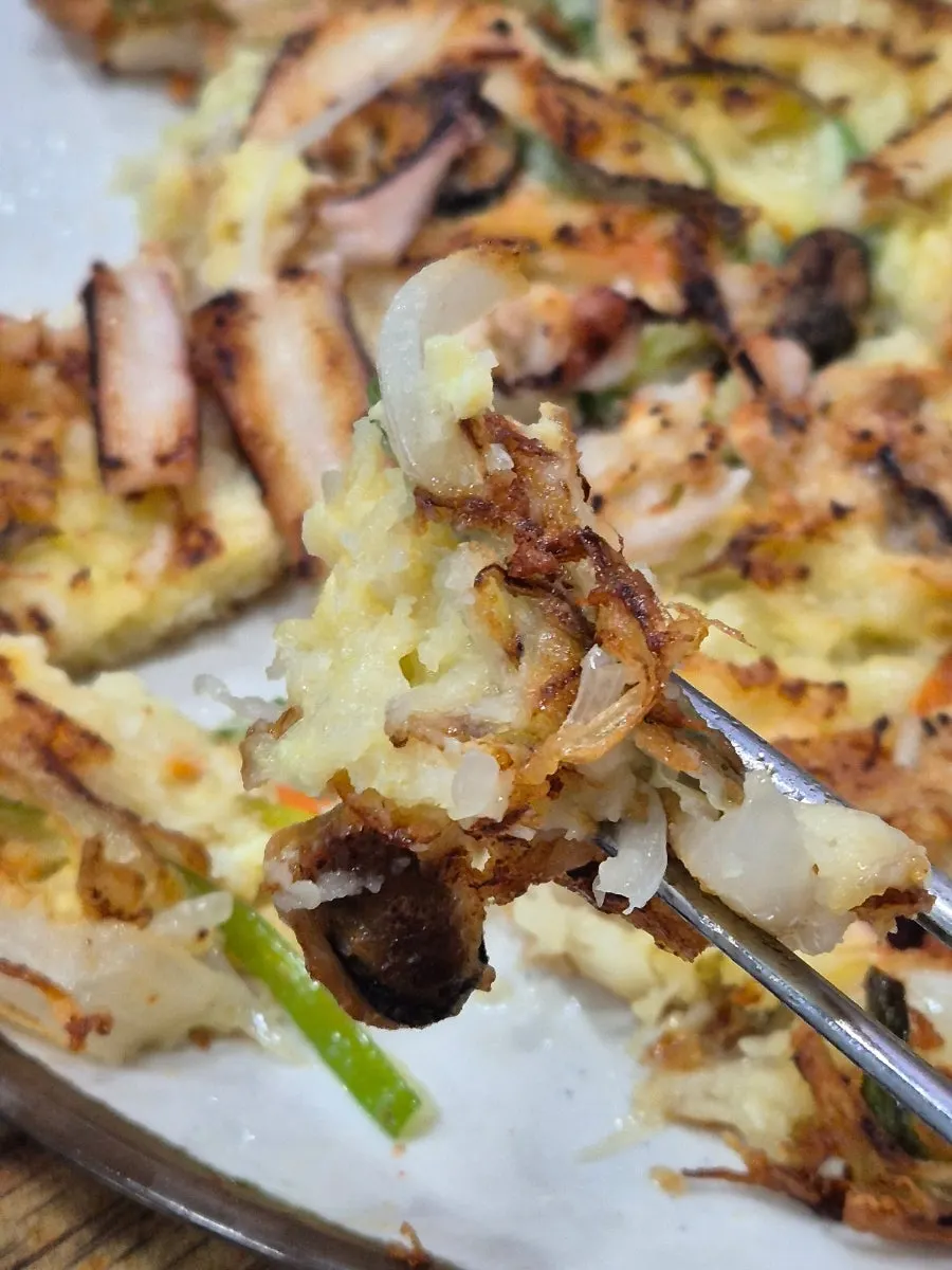 Cross-section of seafood pancake packed with seafood