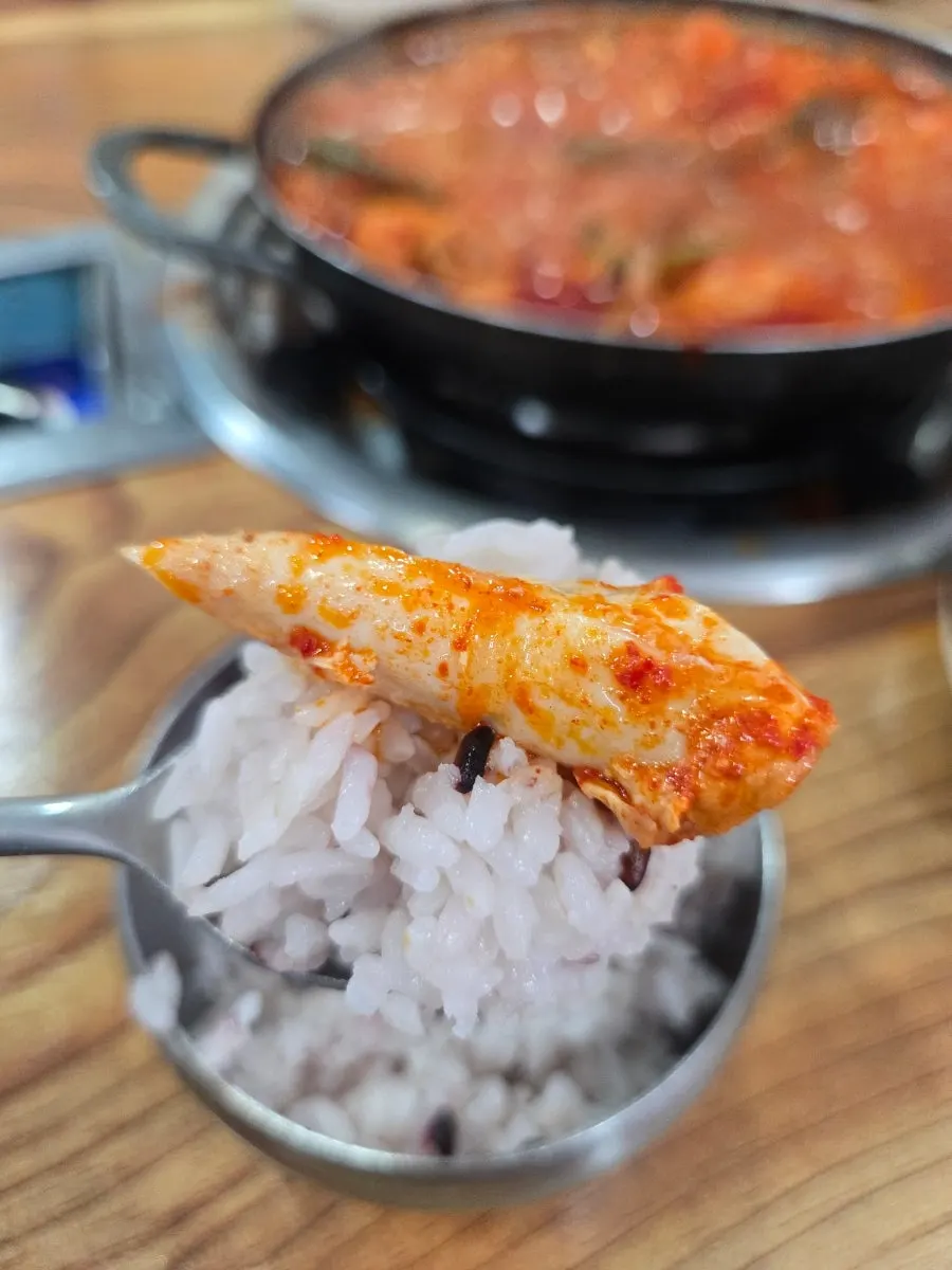 A spoonful of rice mixed with potato and broth