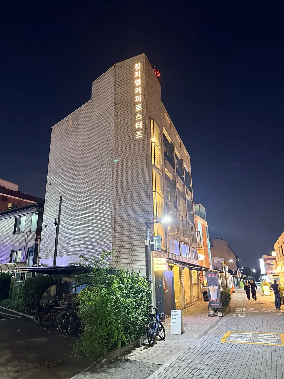 Exterior sign of Jeong Ji-young Coffee Roasters Haenggung Main Branch lit up in the evening