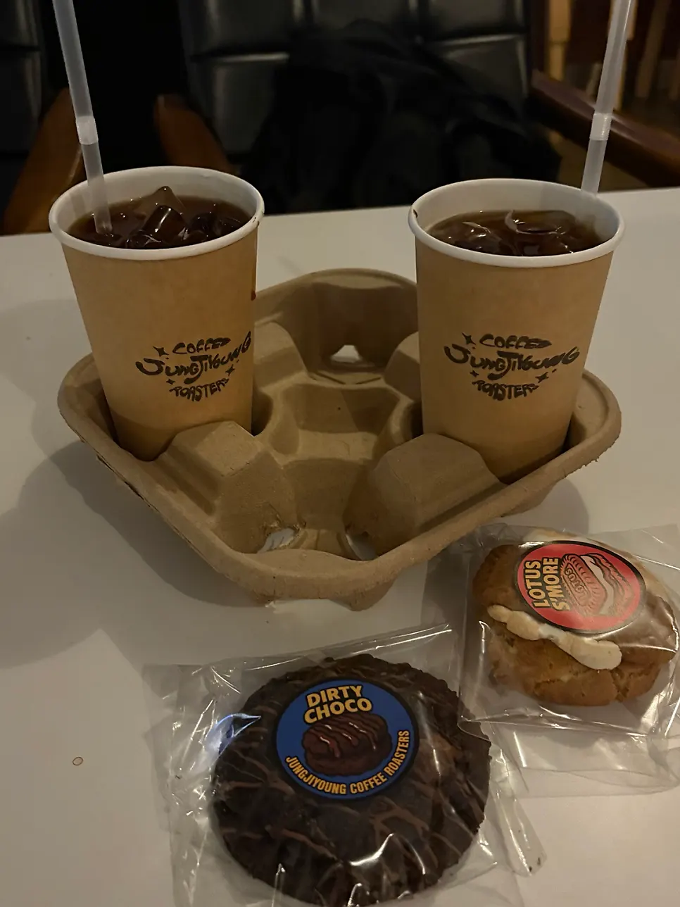 Two iced americanos and wrapped cookies on the table