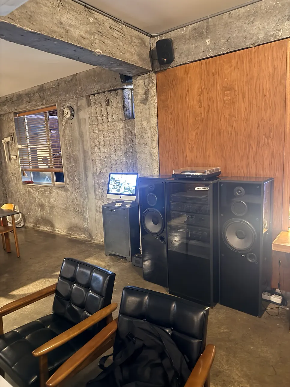 Upstairs seating with exposed concrete walls and wood furniture