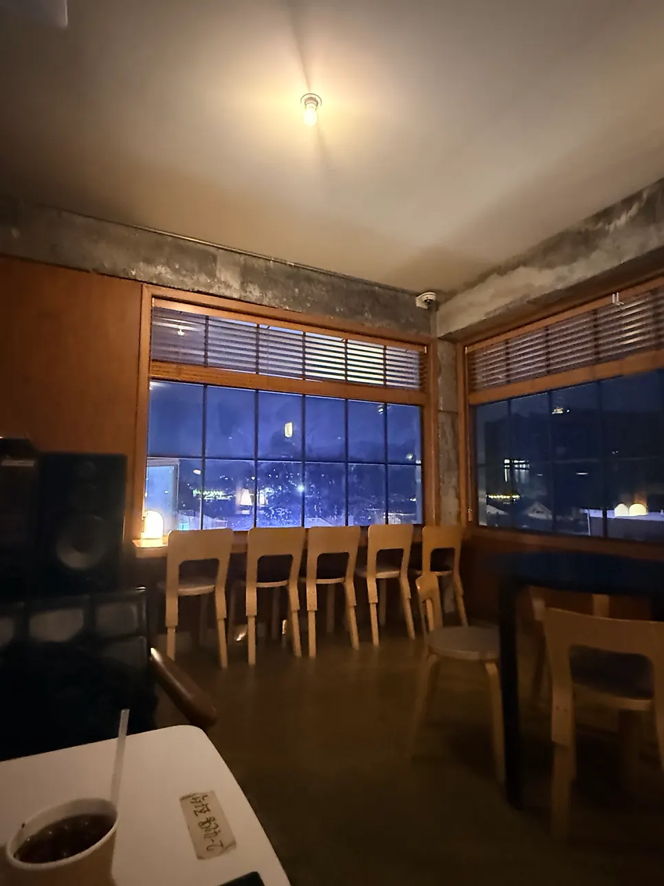Round table seating with a large black light fixture hanging low