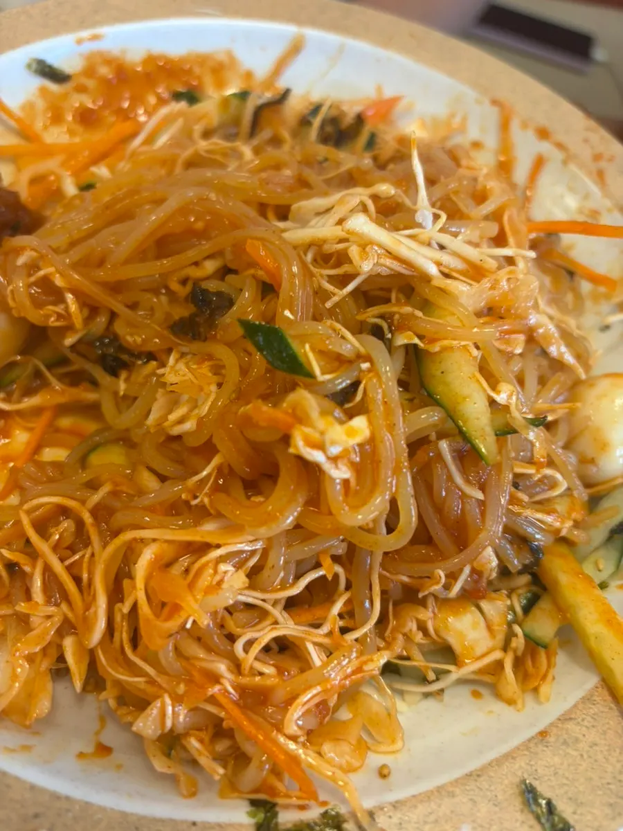 Bowl of jjolmyeon topped with vegetables and seaweed