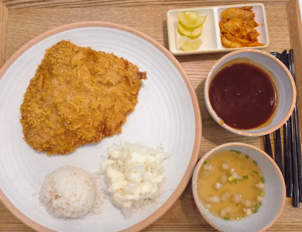 넓은 테이블에 함께 차려진 돈까스 정식 세 가지