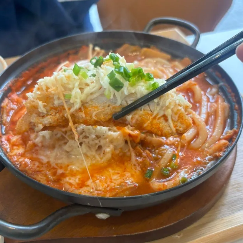 Chewy udon noodles lifted from the kimchi cheese nabe broth