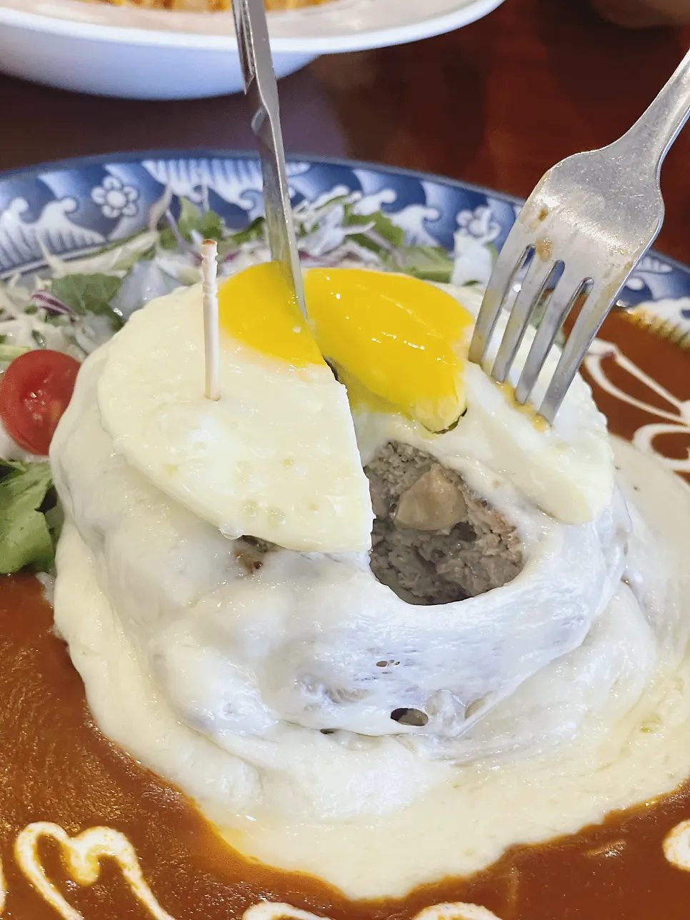 Close-up of mozza cheese hambak topped with cheese and egg