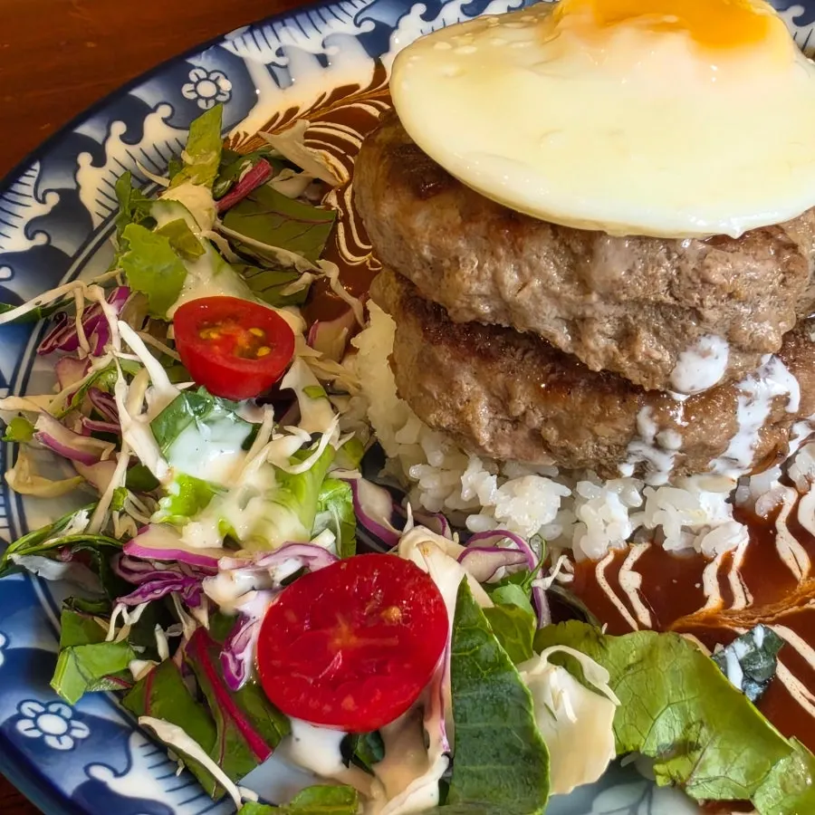 Hamburg steak generously topped with sauce, served with salad