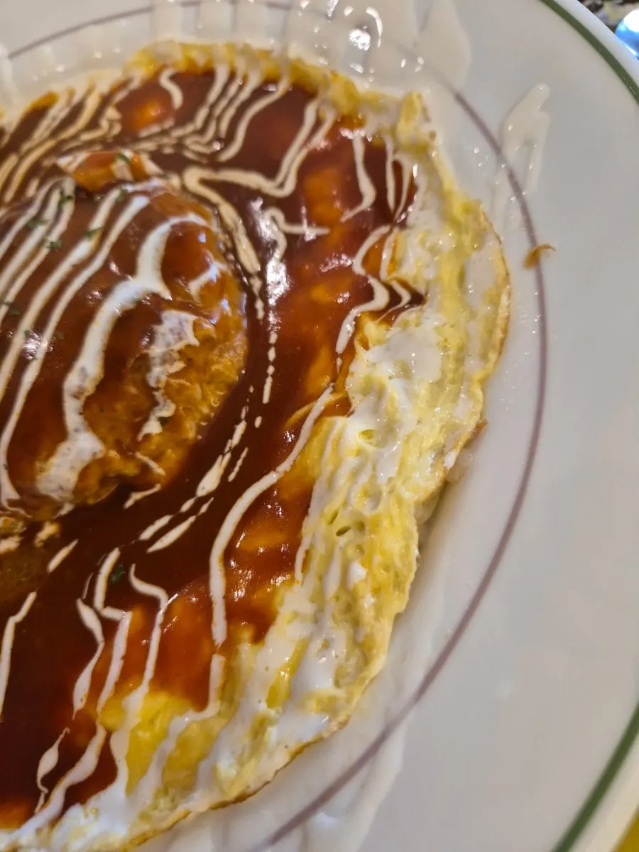 Hamburg steak omurice topped with sauce over an egg sheet
