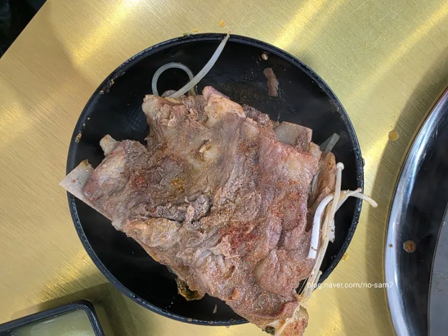 살코기에 숙주와 시래기를 올려 겨자 소스에 찍는 모습