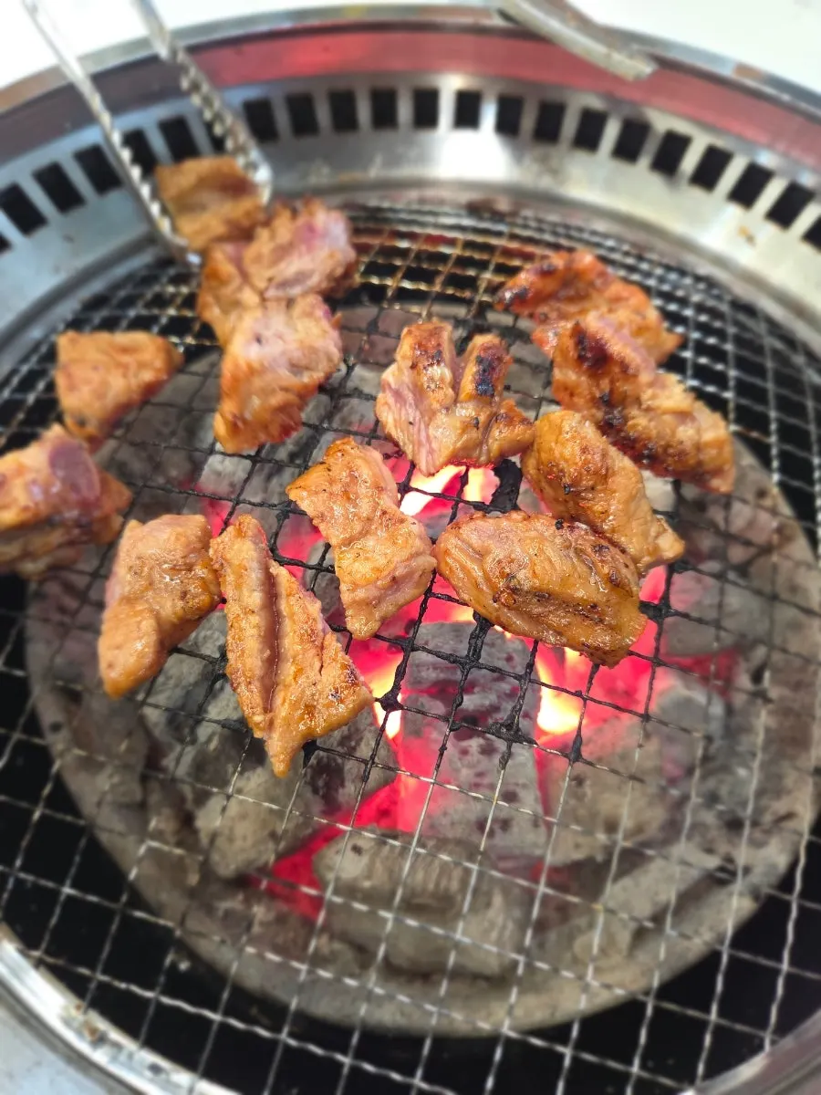 Seasoned pork galbi flipped while grilling