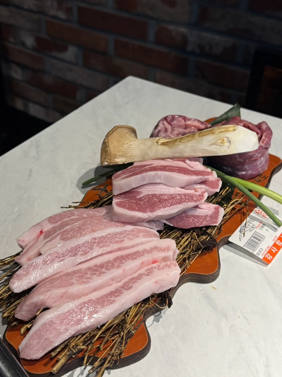 Jeongyukdo's pork specialty cuts set served on a labeled wooden tray