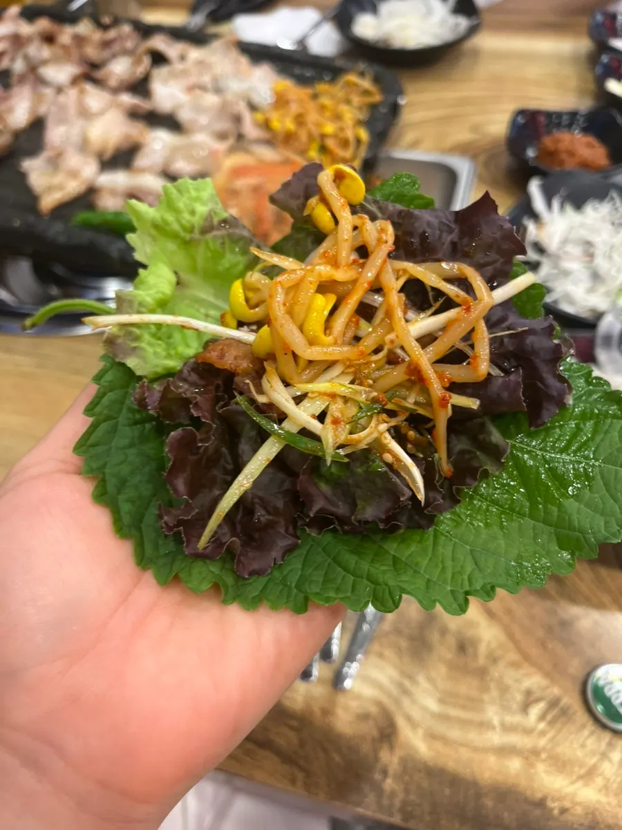 구운 고기로 김치를 싸 먹는 한 점