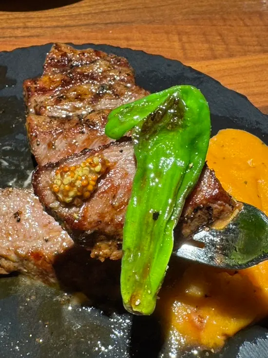 ステーキと青唐辛子を一緒に盛った皿