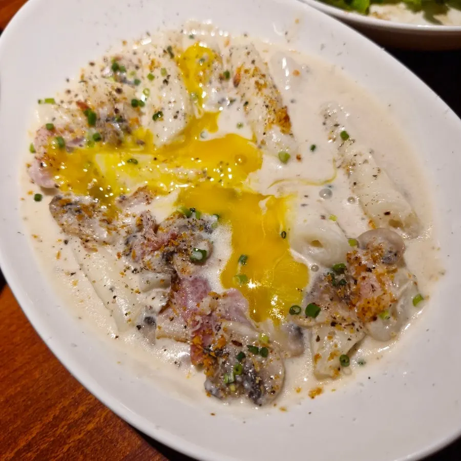 Close-up of rich cream-coated carbonara tteokbokki