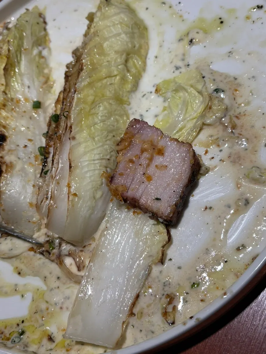 Pork belly steak placed on grilled cabbage