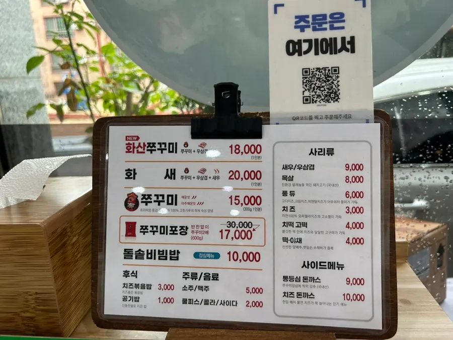 Menu board showing jjukkumi dishes and prices at Jeonju Jjukkumi Sinhwa