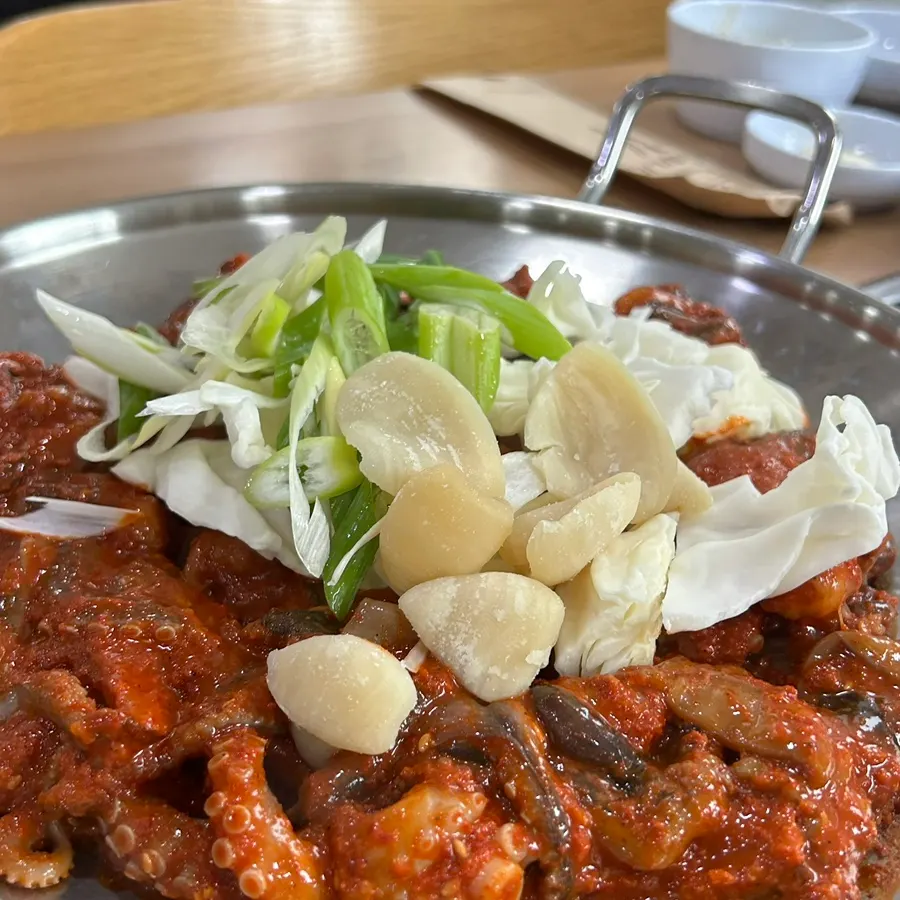 Jjukkumi stir-fry topped with cabbage, green onion, and sujebi